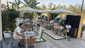 a group of people sitting at tables at an outdoor restaurant at Golden Gate Hotel Hawassa in Āwasa