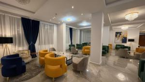 a lobby with a waiting room with yellow and blue chairs at Golden Gate Hotel Hawassa in Āwasa