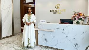 a woman in a white dress standing next to a counter at Golden Gate Hotel Hawassa in Āwasa