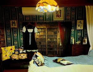 a bedroom with a bed and a dress hanging on a rack at Kirisame Magic Shop霧雨魔法店民泊伊勢市 in Ise