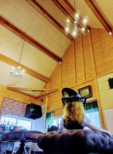 a woman wearing a cowboy hat sitting on a couch at Kirisame Magic Shop霧雨魔法店民泊伊勢市 in Ise