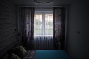 een slaapkamer met een raam en een bed in een kamer bij Jaukus butas Klaipėdos centre in Klaipėda