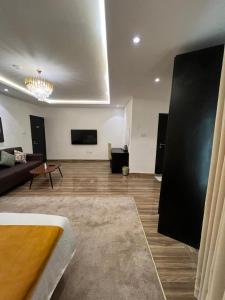 a living room with a couch and a flat screen tv at HomeWorth Hotel in Efiran