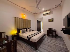 a bedroom with a bed and a flat screen tv at Atulya Niwas in Udaipur +66 photos