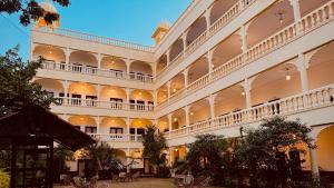 a large building with tables and chairs in a courtyard at Atulya Niwas in Udaipur