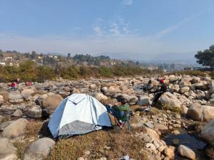 a person sitting in a chair next to a tent at Sunrise Vista Resort & Hotel in Bāgeshwar