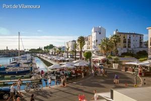 a group of people walking around a marina with boats at Apartment in Algarve,Vilamoura in Vilamoura