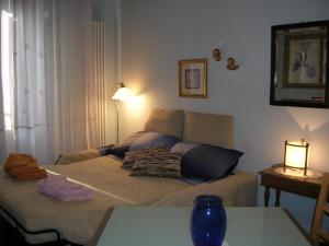 ein Schlafzimmer mit einem Bett und einem Tisch mit einer Lampe in der Unterkunft Macri in Montagnana