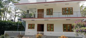 ein Haus mit einem Balkon darauf in der Unterkunft Silver homestay in Vagamon
