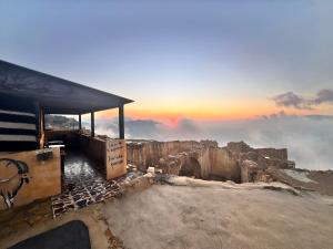 a building on top of a mountain with the sunset at TOWER Hotel in Dana +44 photos