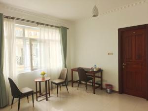 a dining room with a table and chairs and a window at Zawadi Apartment in Dar es Salaam