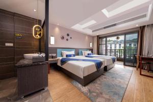 a bedroom with a bed and a sink and a tub at Phoenix Ancient Hill Riverside View Hotel- Offers free one-way high-speed rail pick-up service - Afternoon tea - Self-service laundry - Baggage storage - Travel planning in Fenghuang County +112 photos