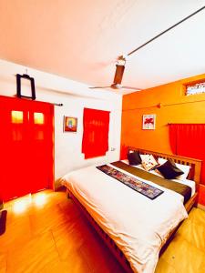 een slaapkamer met een groot bed met rode accenten bij Crazy Camel Hotel & Safari in Jaisalmer