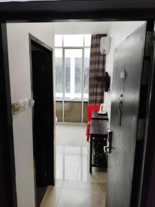 an open door to a kitchen with a red table at comfortpahlawan in Sibu