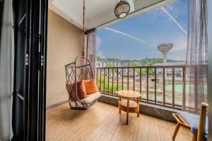 a balcony with a swing and a view of the space needle at Phoenix Ancient Hill Riverside View Hotel- Offers free one-way high-speed rail pick-up service - Afternoon tea - Self-service laundry - Baggage storage - Travel planning in Fenghuang County