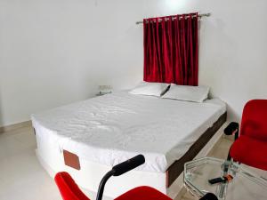 a microphone in front of a bed with a red curtain at Glory Farm in Vadāli