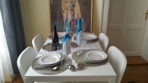 a white table with white chairs and a table with plates and dishes at BMG Apartment Basilica in Budapest