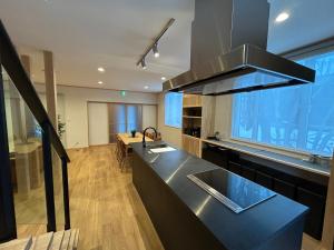 a kitchen with a black counter top and a kitchen island at Hakuba Powder Cottage Eden in Hakuba