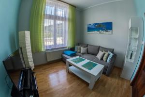 - un salon avec un canapé et une table dans l'établissement Apartament Zdrojowa 45, à Kudowa-Zdrój