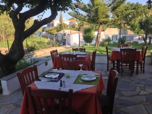 a restaurant with tables and chairs with red table cloth at Vontzos Hotel in Achladies