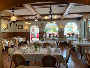 ein Esszimmer mit weißen Tischen und Stühlen in der Unterkunft Karnischer Hof in Sankt Stefan an der Gail