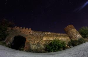an old brick wall with an archway at night at Galavnis Kari Hotel in Sighnaghi
