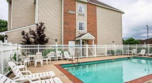 una piscina davanti a una casa con recinzioni bianche di Quality Inn & Suites a Belinda City Altre 79 foto