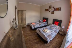 a bedroom with two beds and a clock on the wall at Apartament Zdrojowa 45 in Kudowa-Zdrój