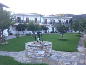 a building with a statue in the middle of a yard at Vontzos Hotel in Achladies