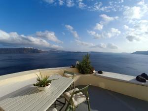 un tavolo e sedie su un balcone affacciato sull'acqua di Elias Cave House 270o Caldera View Oia a Oia