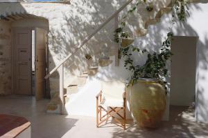 a plant in a large vase next to a staircase at En Patmo Holiday Home in Patmos