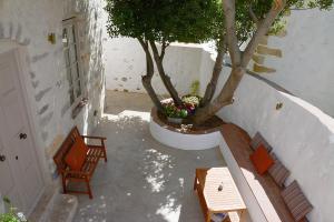 a staircase with two chairs and a tree in a pot at En Patmo Holiday Home in Patmos