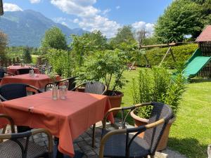 eine Terrasse mit Tischen und Stühlen sowie einem Spielplatz in der Unterkunft Karnischer Hof in Sankt Stefan an der Gail