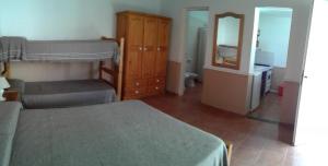 een slaapkamer met een bed, een dressoir en een spiegel bij Monoambientes Low Cost in Villa Cura Brochero