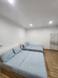 a bedroom with two beds with blue pillows at 198 House in Ban Khlong Pleo