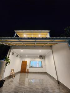 a view of a white building with a wooden door at 198 House in Ban Khlong Pleo