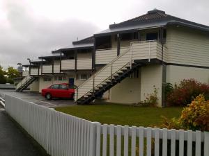 a house with a red car parked in front of it at Motel Six in Hamilton