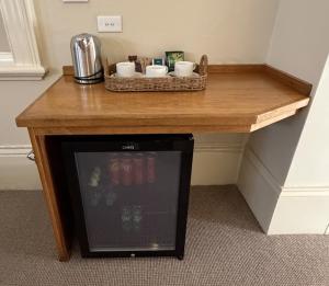 a wooden table with cups and cups on it at Campbell st Lodge in Castlemaine