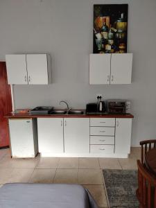 a kitchen with white cabinets and a counter top at Heights in Cedara
