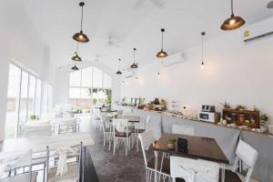 a dining room with white tables and chairs at NanNakara Boutique Hotel in Nan