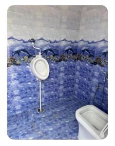a bathroom with a toilet and dolphins on the wall at Hari Vatika in Varanasi