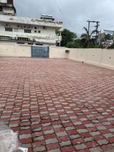 a red brick ground in front of a building at Hari Vatika in Varanasi +3 photos