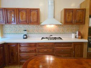 a kitchen with wooden cabinets and a stove top oven at Hillside Villa with ocean views in Puerto Vallarta +49 photos