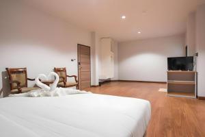 una camera con letto bianco e TV a schermo piatto di CHANTHABURI CENTER a Chanthaburi