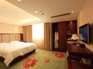 una camera d'albergo con un letto e una televisione di Gui Feng Hotel a Xinhui