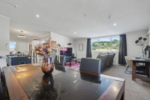 een woonkamer met een vaas met bloemen op een tafel bij The Upper Rooms in Nelson