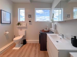 een badkamer met een toilet, een wastafel en ramen bij The Upper Rooms in Nelson +18 foto's