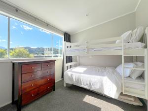een slaapkamer met twee stapelbedden en een raam bij The Upper Rooms in Nelson