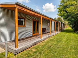 a house with a wooden deck next to a yard at Naseby Apartments in Naseby