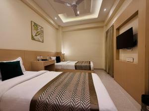 a hotel room with two beds and a flat screen tv at RION - A Boutique Hotel in Udaipur